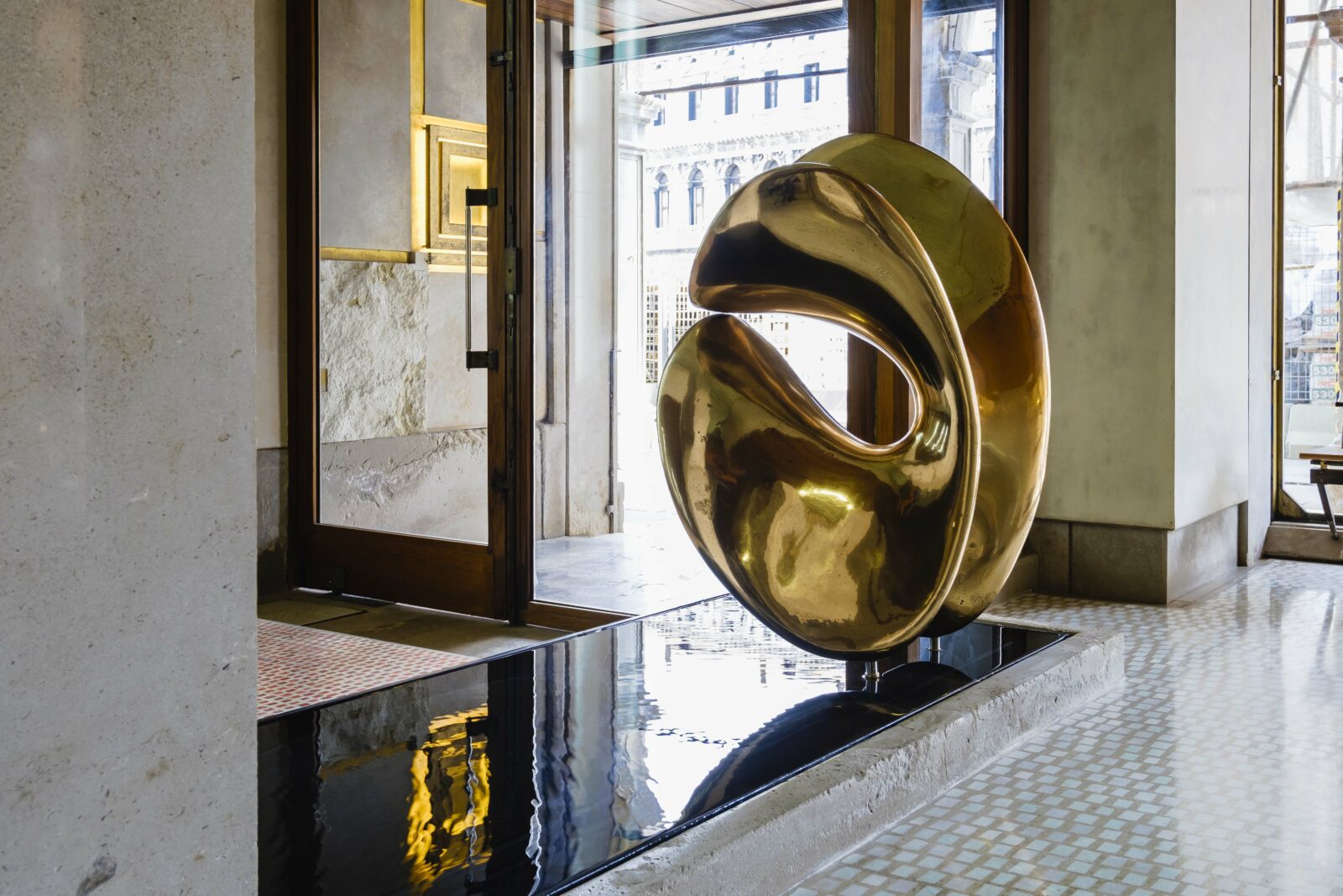 Entrance of the Olivetti Showroom in Venice with fountain and statue